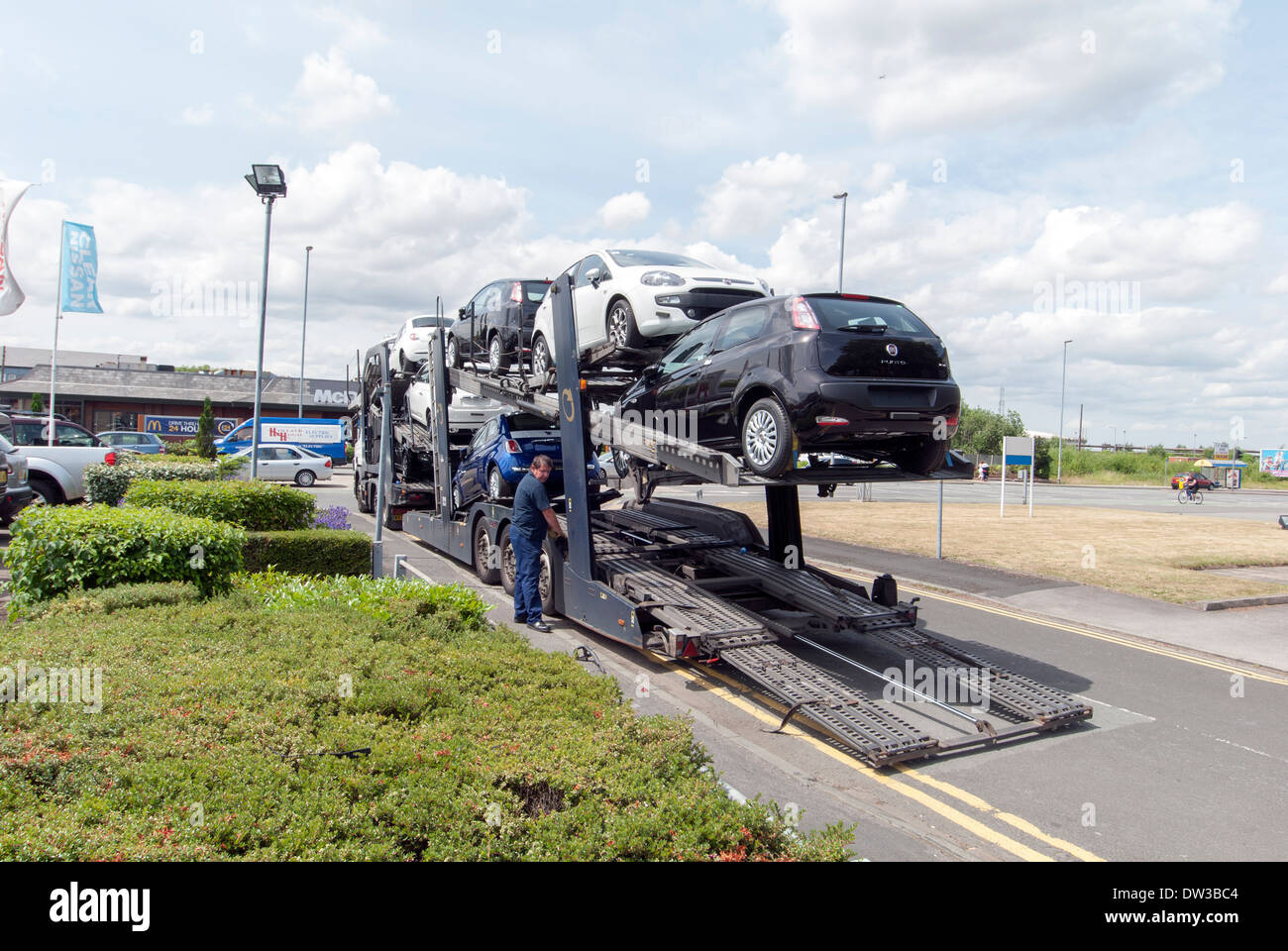 Driver unloading FIAT cars from car transporter, Warrington, Cheshire, UK Stock Photo