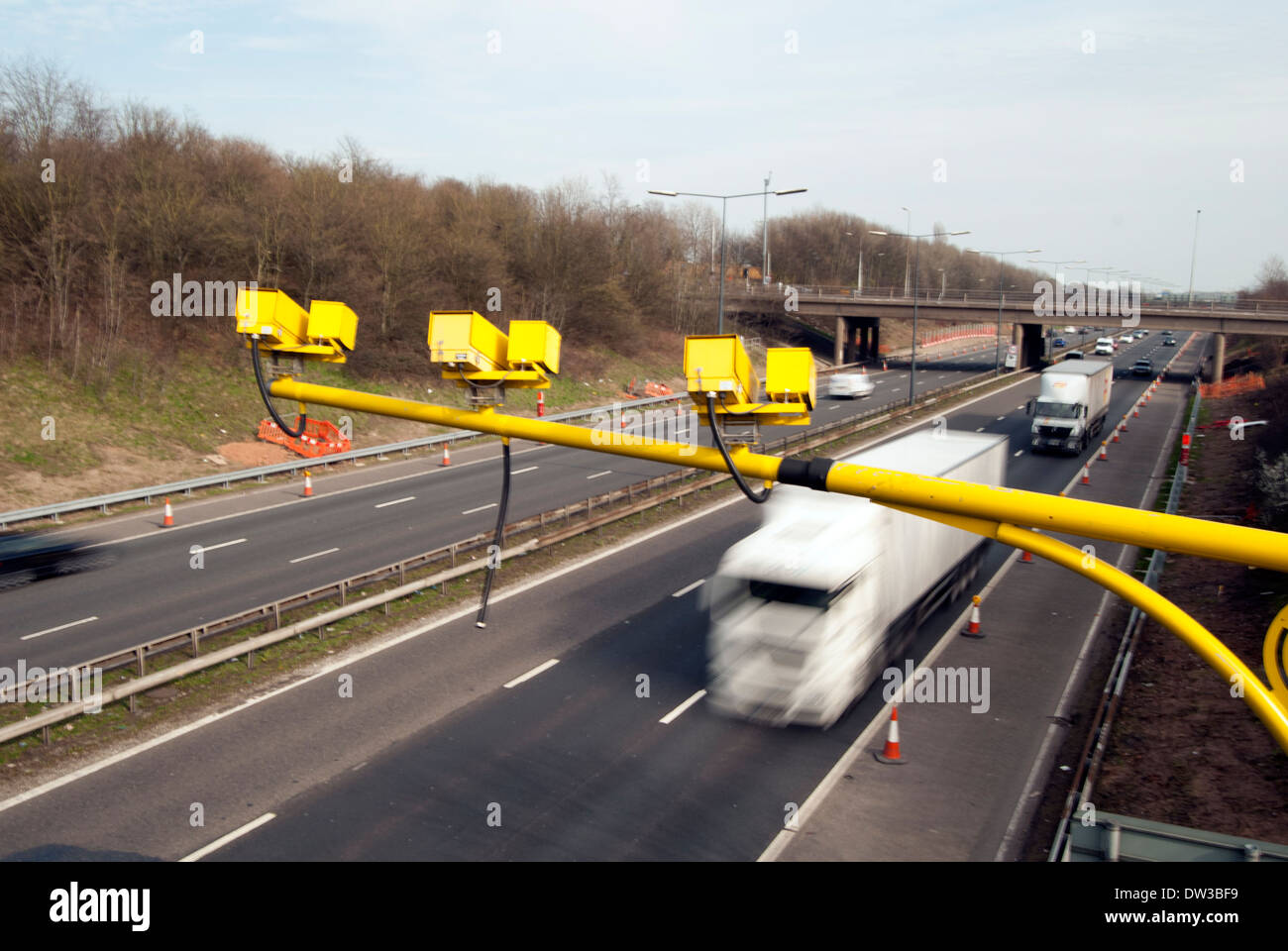Yellow speed camera above motorway bridge, M62, Warrington, Cheshire, UK Stock Photo