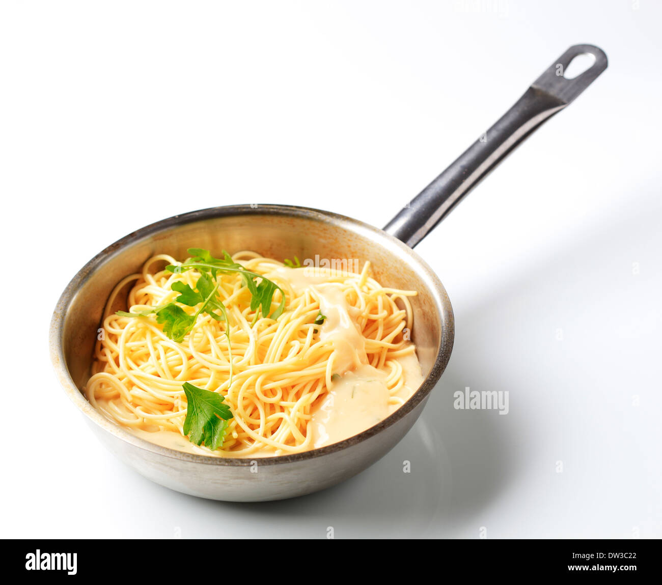 Spaghetti and creamy sauce in a saucepan Stock Photo