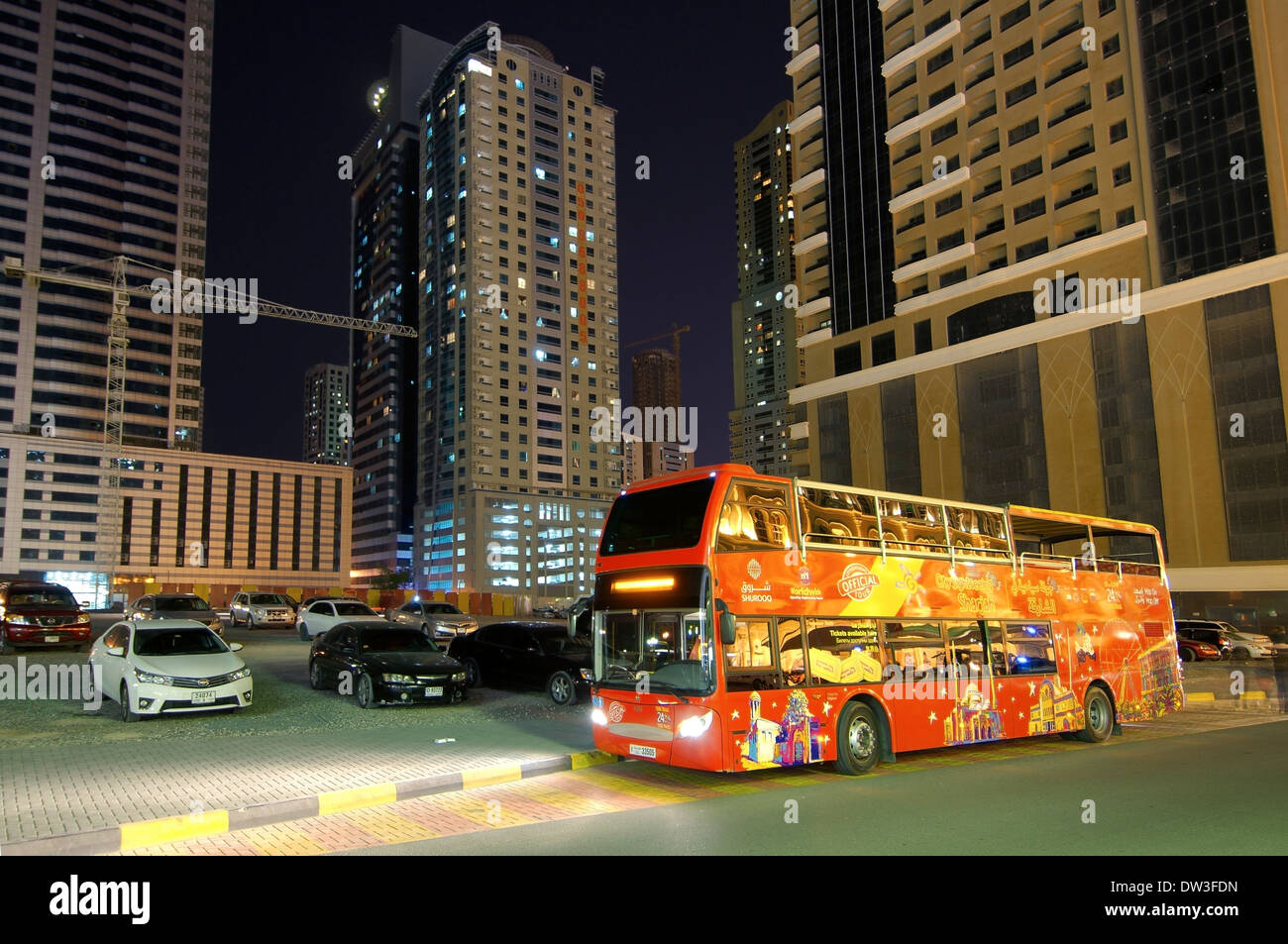 Red double decke tour bus, night city Sharjah, Sharjah (emirate), UAE