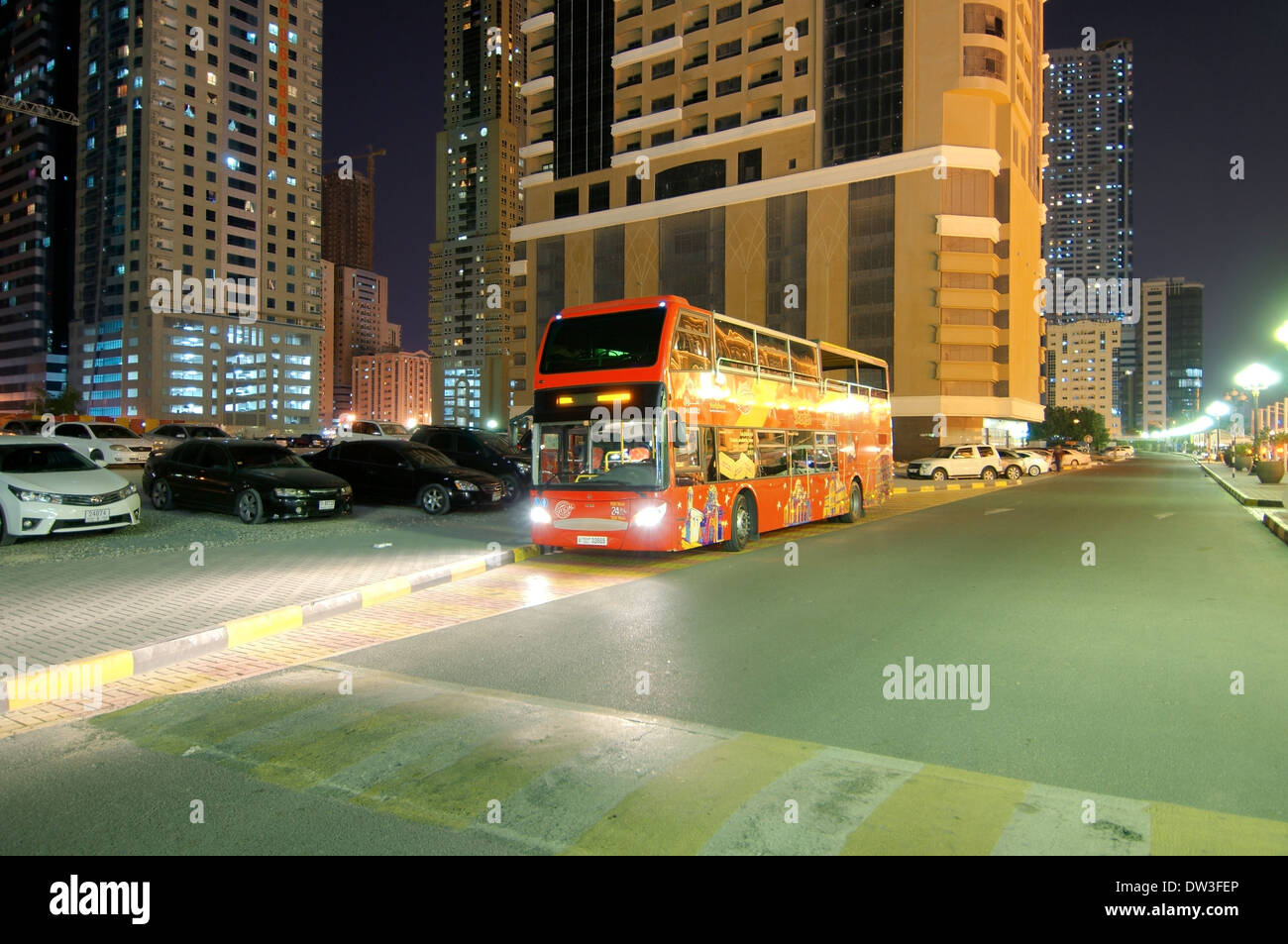Red double decke tour bus, night city Sharjah, Sharjah (emirate), UAE