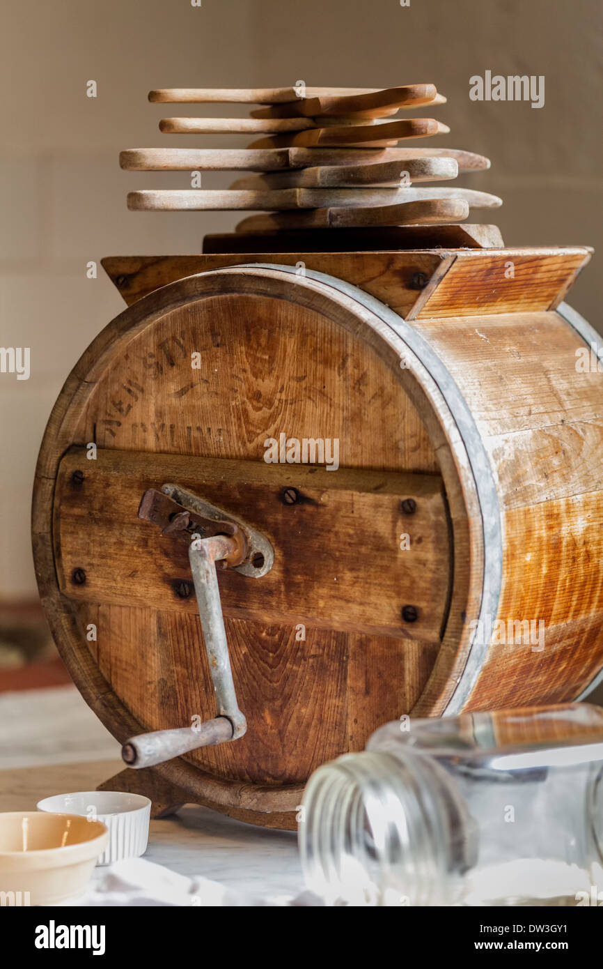 Antique butter churn with butter pats glass jar and ramekin in old farm
