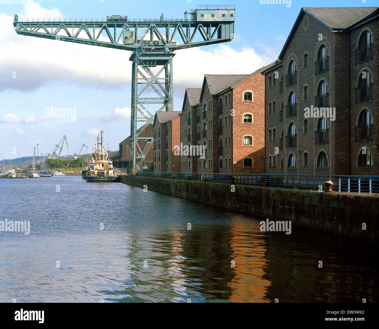 Old crane and new residential apartment blocks in the style of the old sugar warehouse beside the James Watt Dock in Greenock Stock Photo