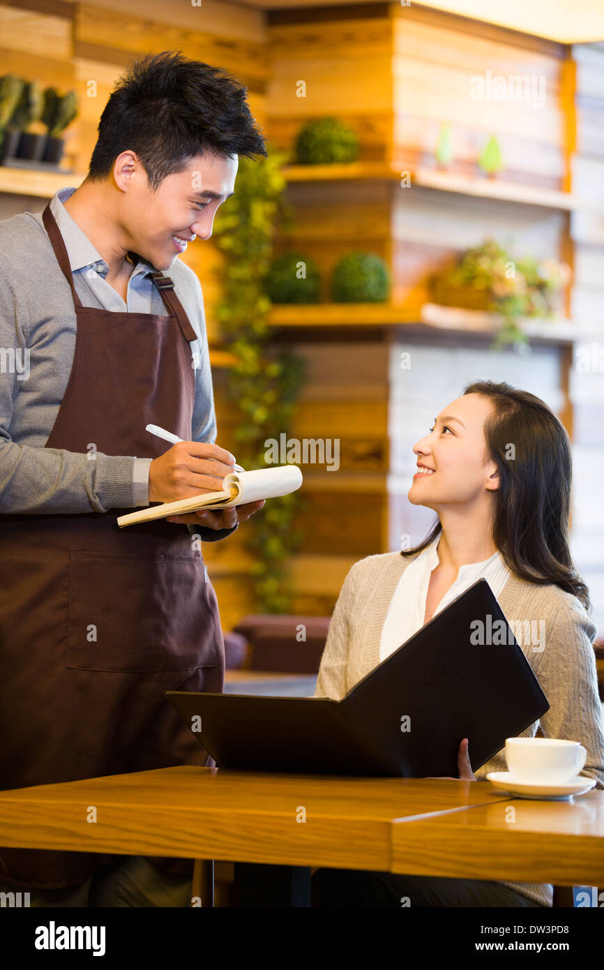 Waiter taking order from woman at restaurant Stock Photo - Alamy
