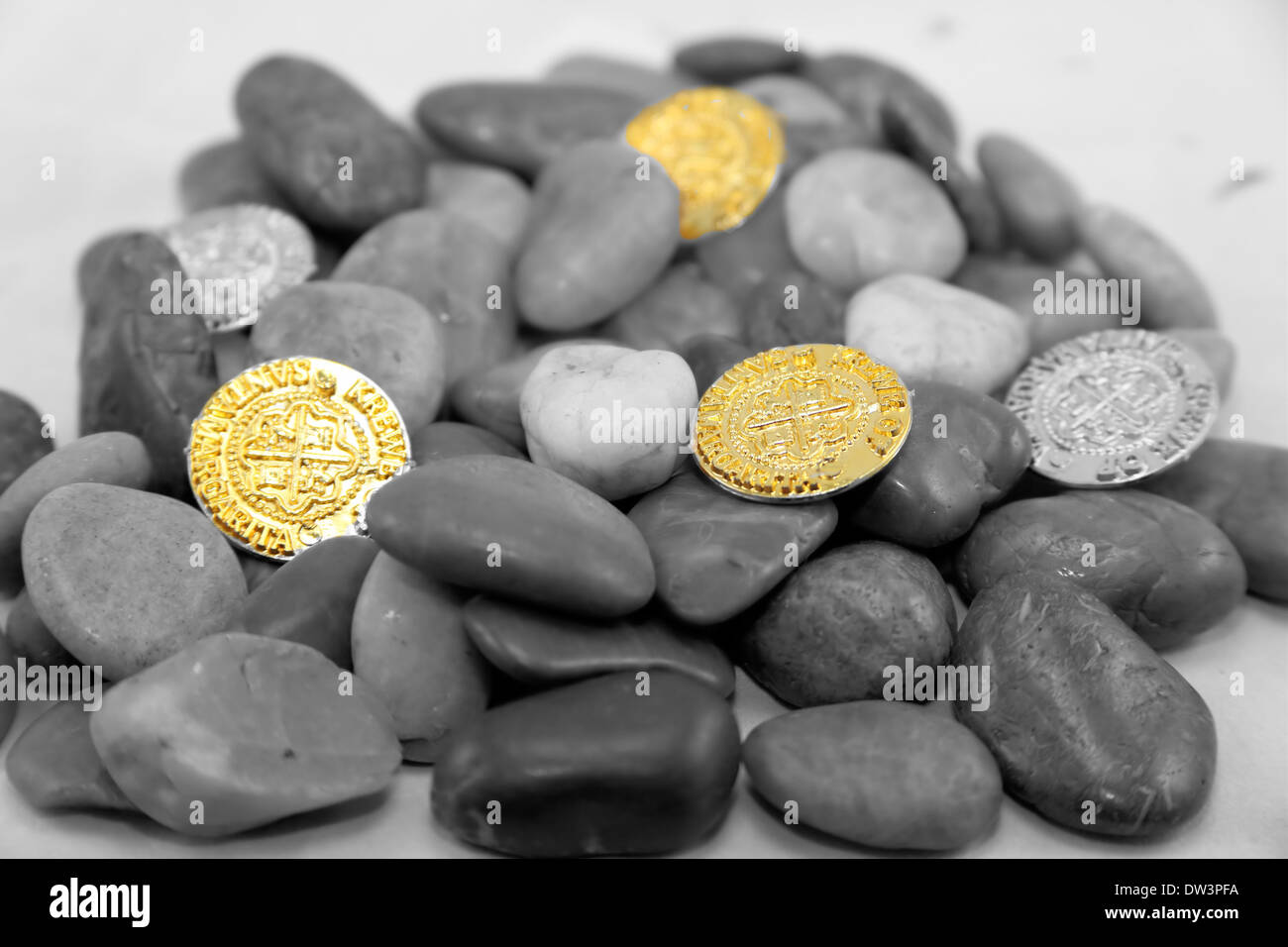 SPANISH OLD GOLD COINS ON MONOCHROME PICTURE.RIVER ROCKS Stock Photo