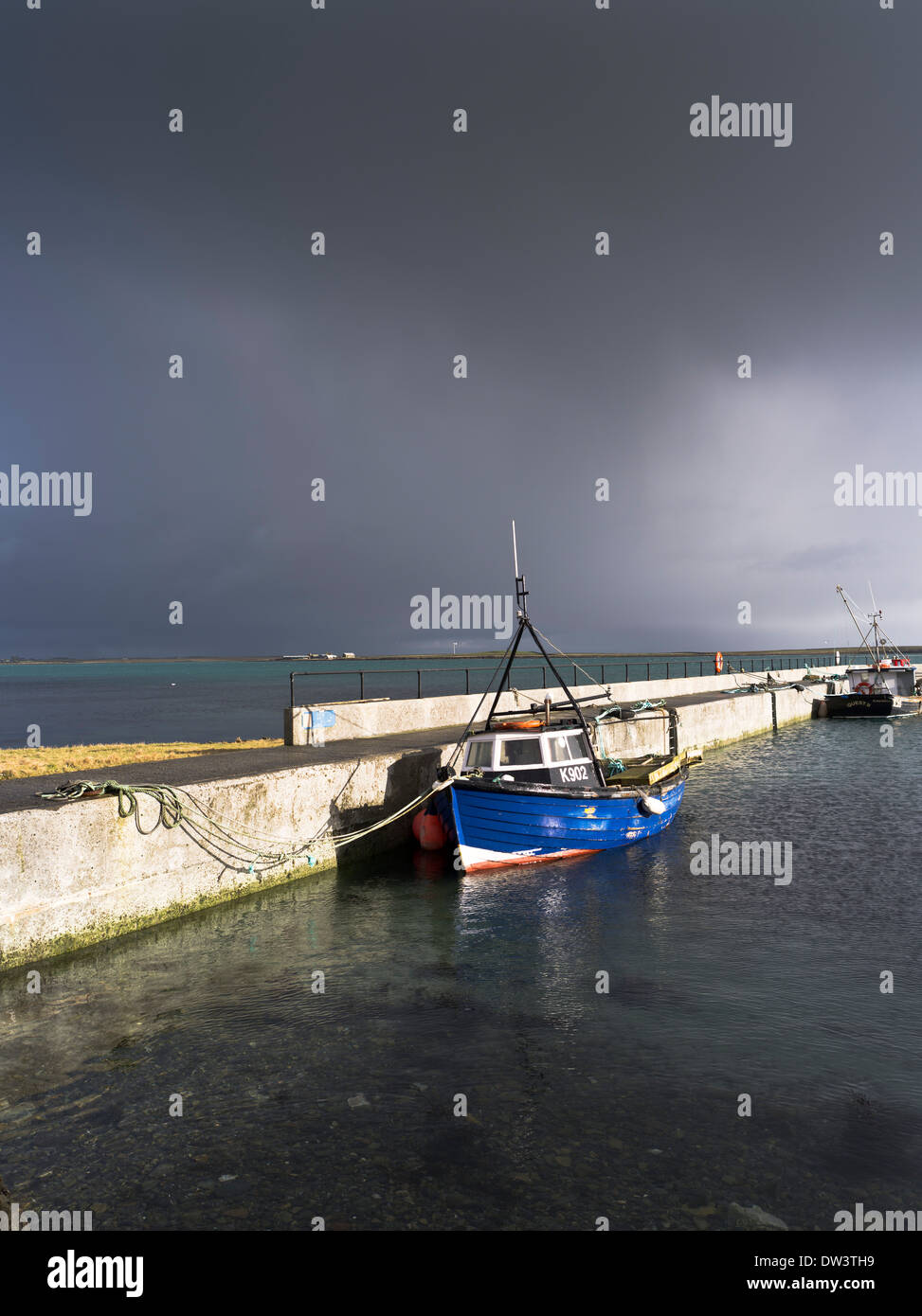 dh Kettletoft harbour SANDAY ORKNEY Gathering storm approaching fishing boat pier scotland clouds orkneys uk bad weather sea boats sunny Stock Photo