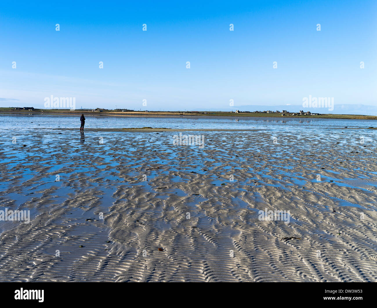 dh Cata Sand SANDAY ORKNEY Woman on beach sand patterns tide out shallow sandy inlet bay Stock Photo