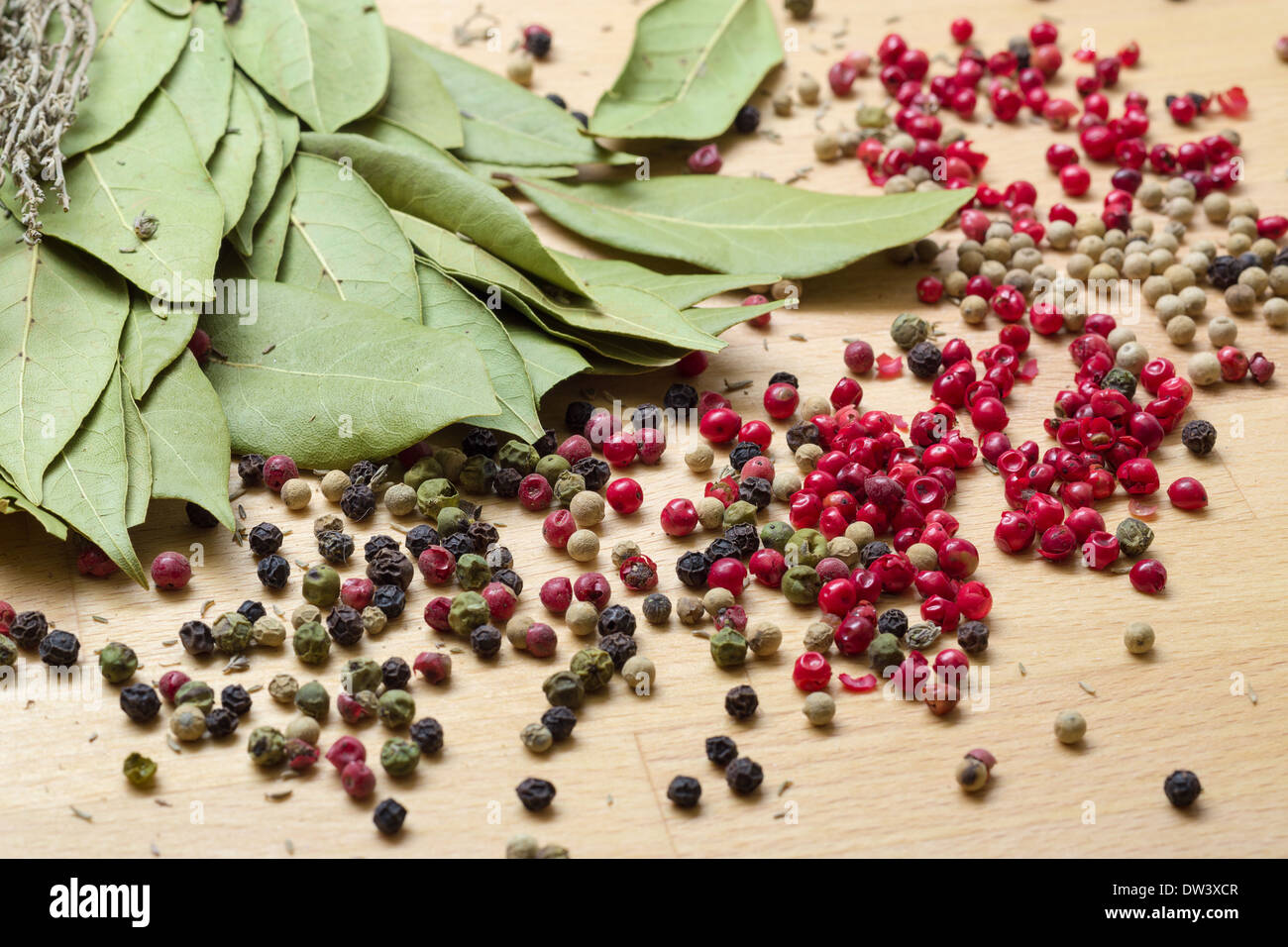 Dry bay laurel leaf with multicolored peppercorn closeup on wooden background Stock Photo