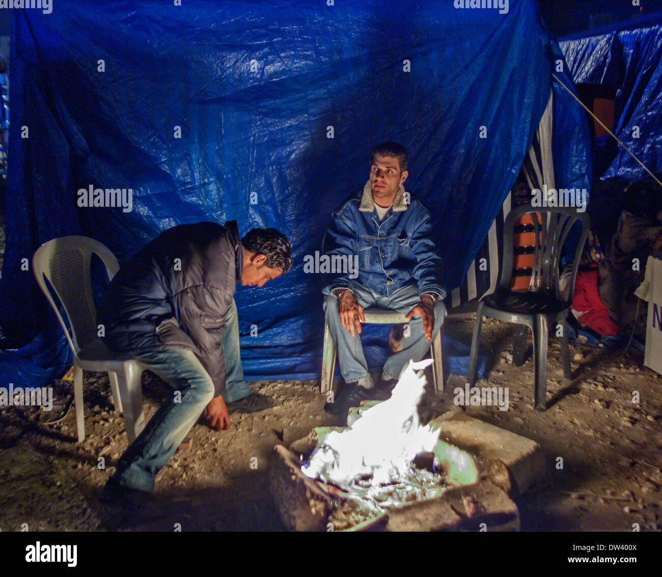 Young protesters gather by a fire in the tent city established in Martyr's Square, Beirut, Lebanon, during the Cedar Revolution. Stock Photo