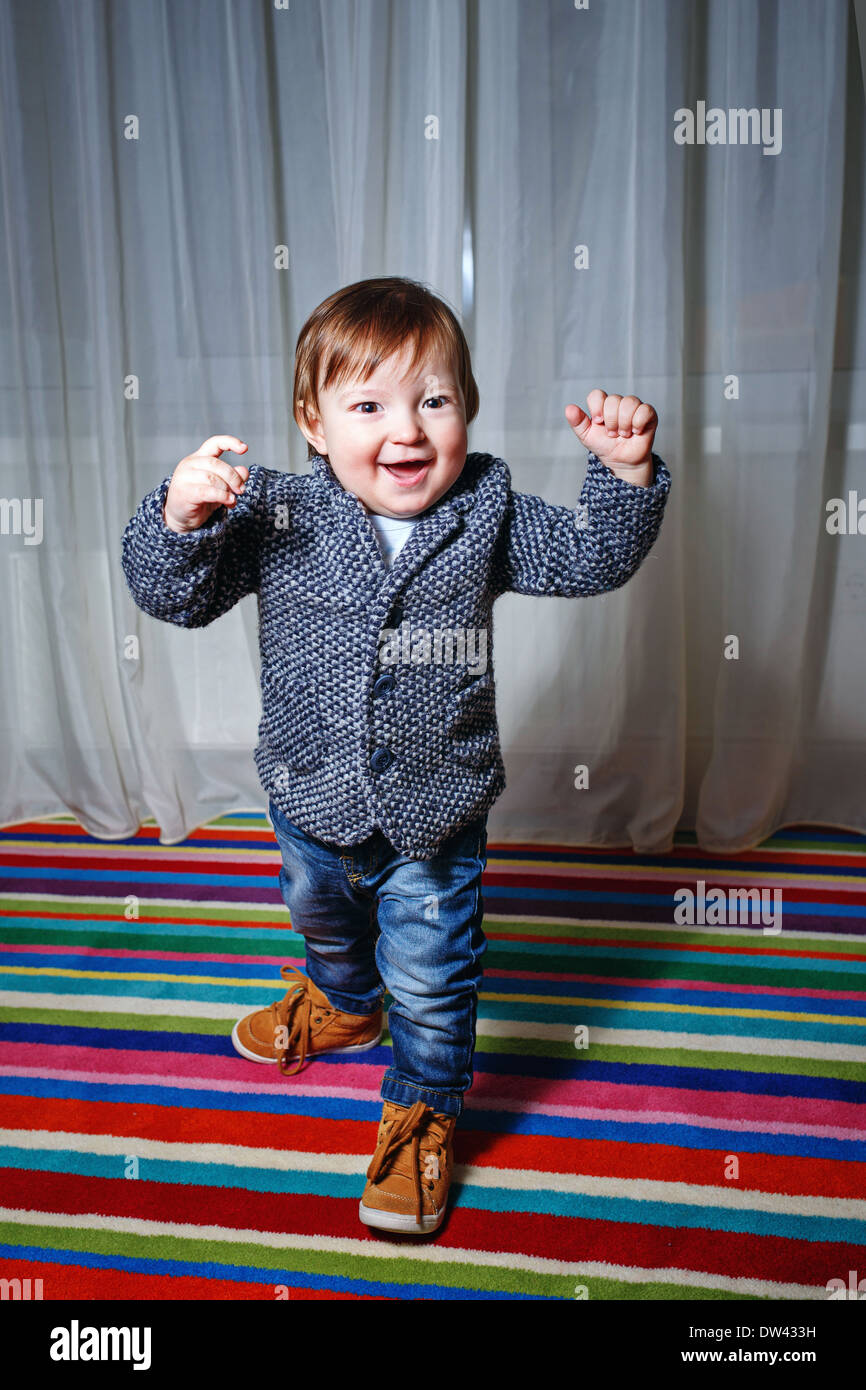 Little boy in a single-breasted jacket and jeans held up his hands in a  moment of joy Stock Photo - Alamy