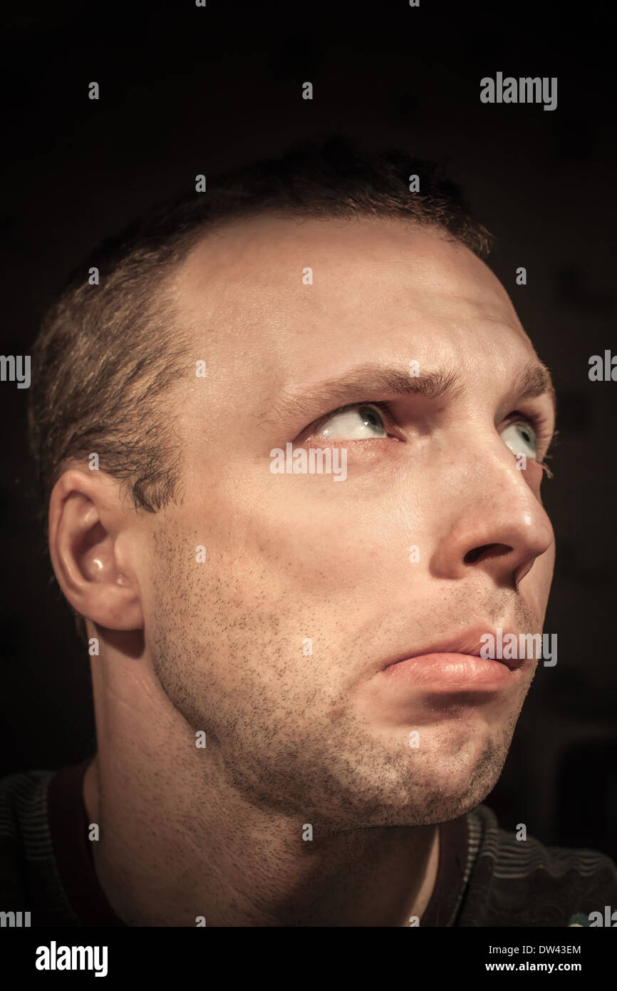 Young confused thinking Caucasian man portrait on dark background Stock Photo