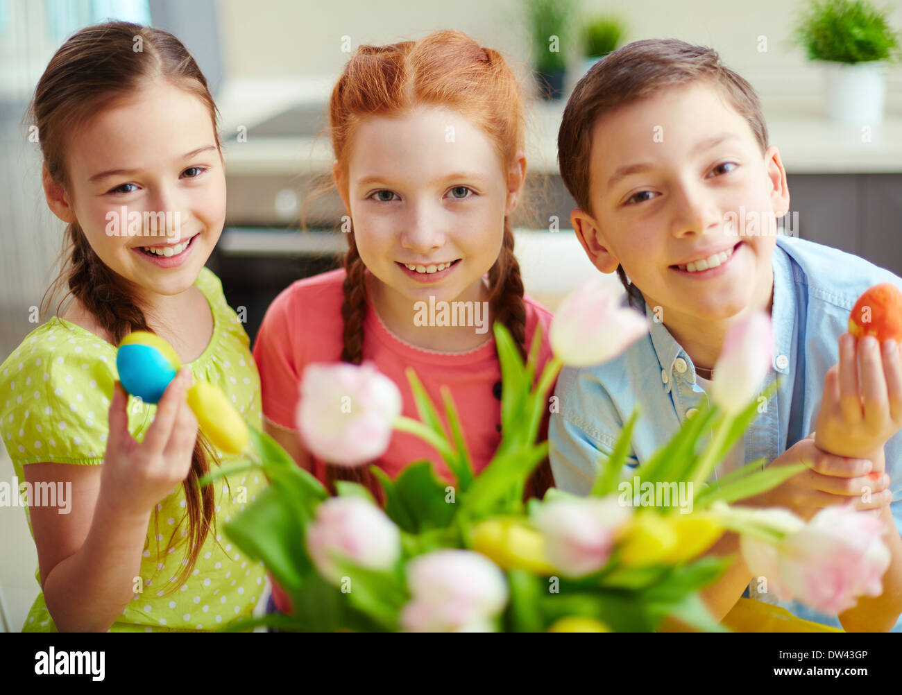 Portrait of three smiling children with Easter eggs Stock Photo