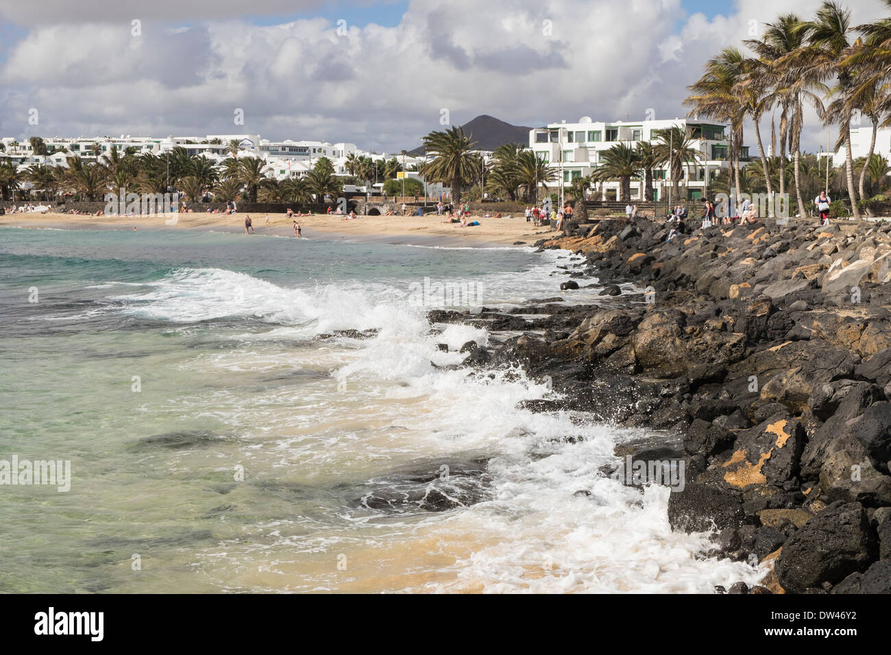 View along rocky seashore to sandy Playa de las Cucharas beach in Costa Teguise, Lanzarote, Canary Islands, Spain Stock Photo