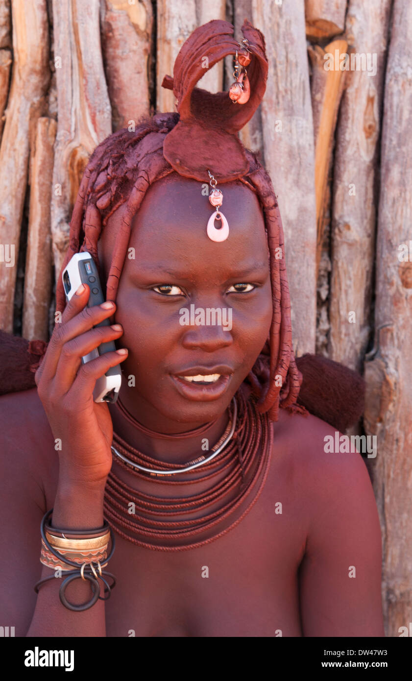 Namibia Africa remote nomadic Himba tribe young women with braids on modern  cell phone and traditional dress in desert Stock Photo - Alamy