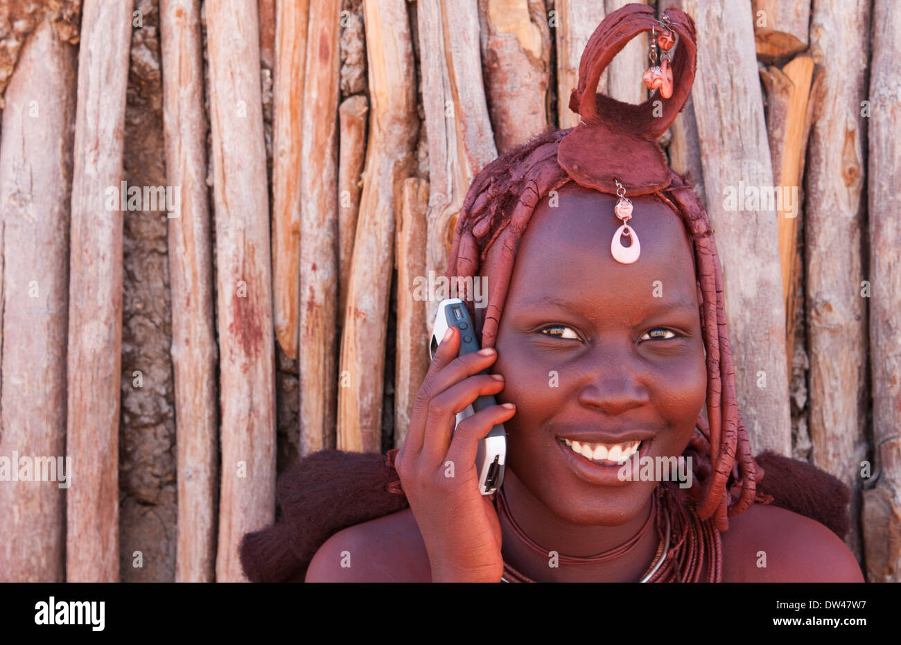 Namibia Africa remote nomadic Himba tribe young women with braids on modern  cell phone and traditional dress in desert Stock Photo - Alamy
