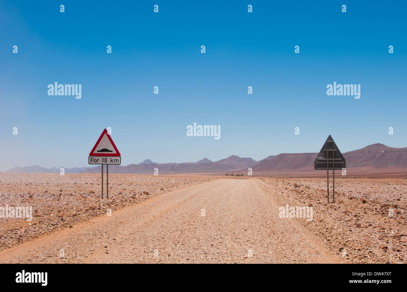 Namibia Africa Northern Desert of Namib Desert remote road with bump sign in Hartmann Berge deserted land Hartmann Valley Stock Photo