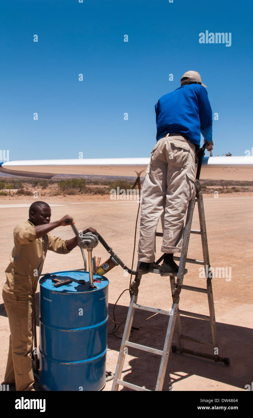 Namibia Namib Desert refueling plane in the Hartmann Berge Marienflub sand remote landing strip with workers pumping Stock Photo