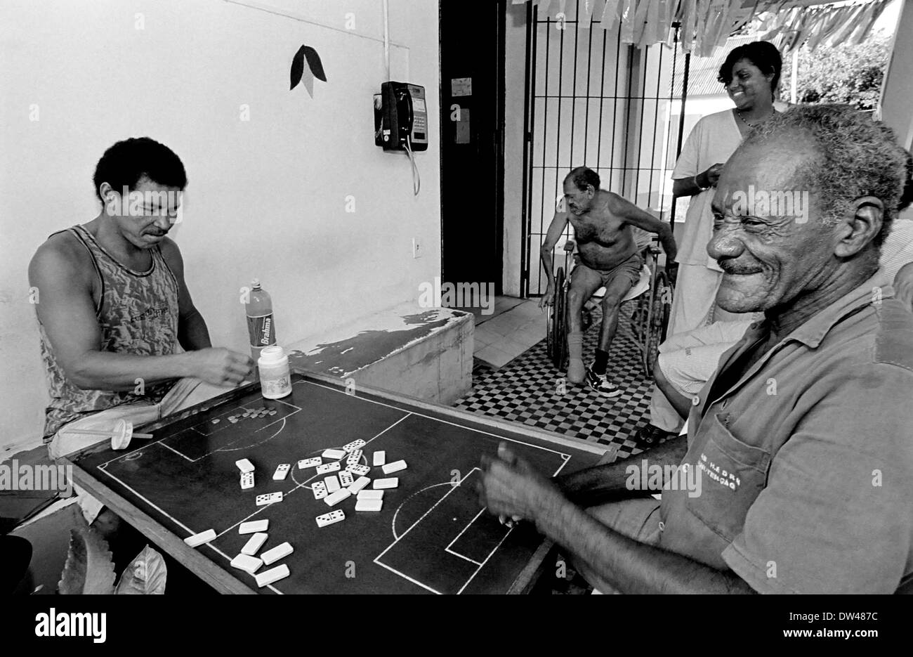 Men in Brazil play domino and talk and discuss about politics, football and community problems. Leprosy is a chronic infection Stock Photo