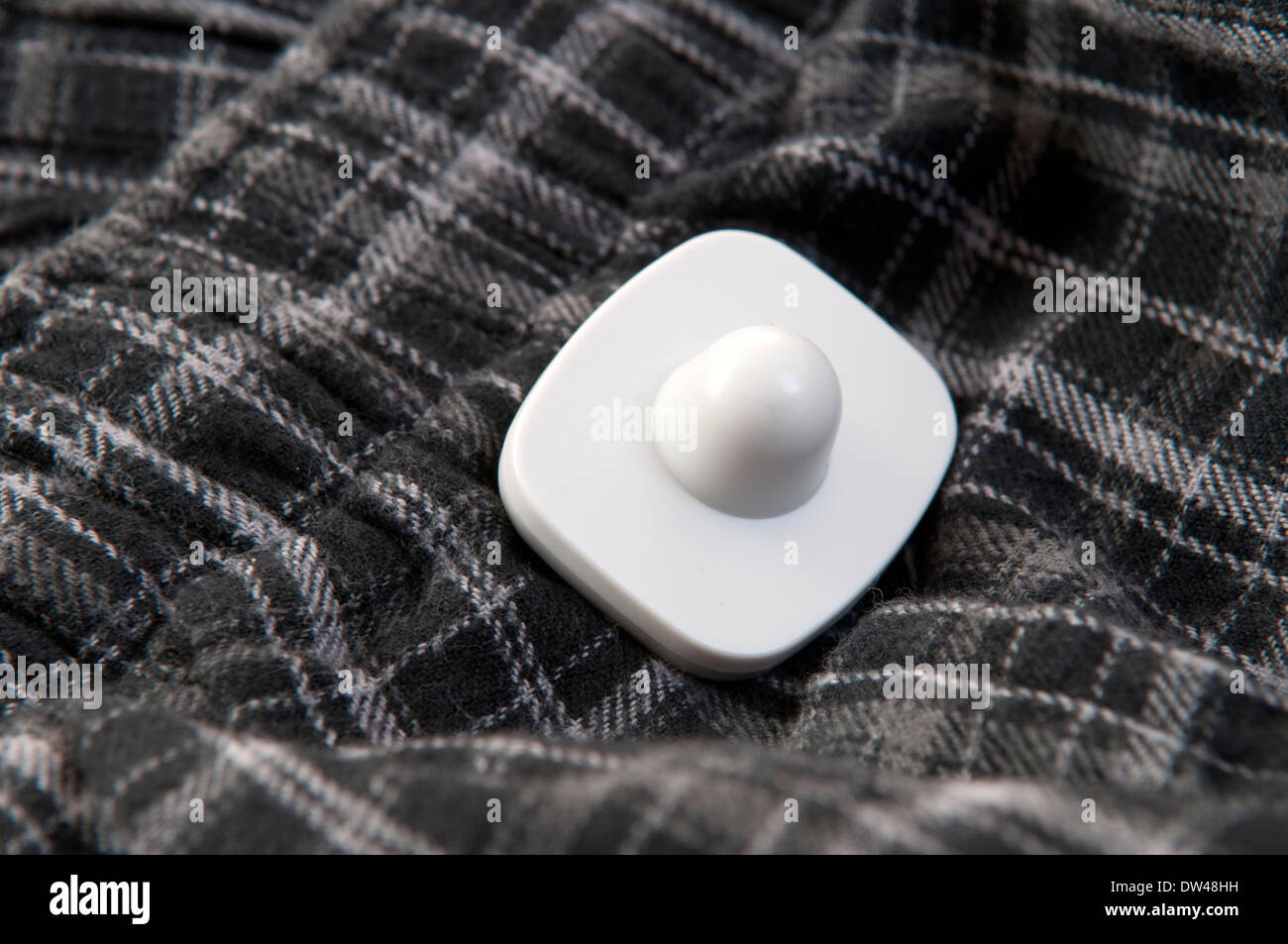 Shop security tag attached to an item of clothing Stock Photo Alamy