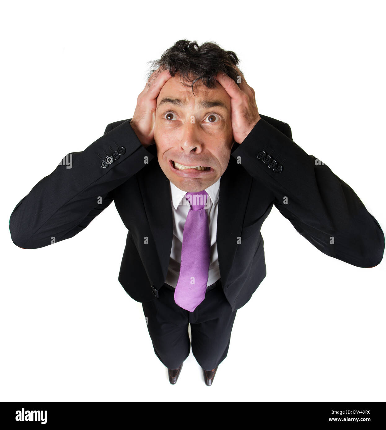 High angle full length portrait of an expressive anxious businessman tearing at his hair isolated on white Stock Photo