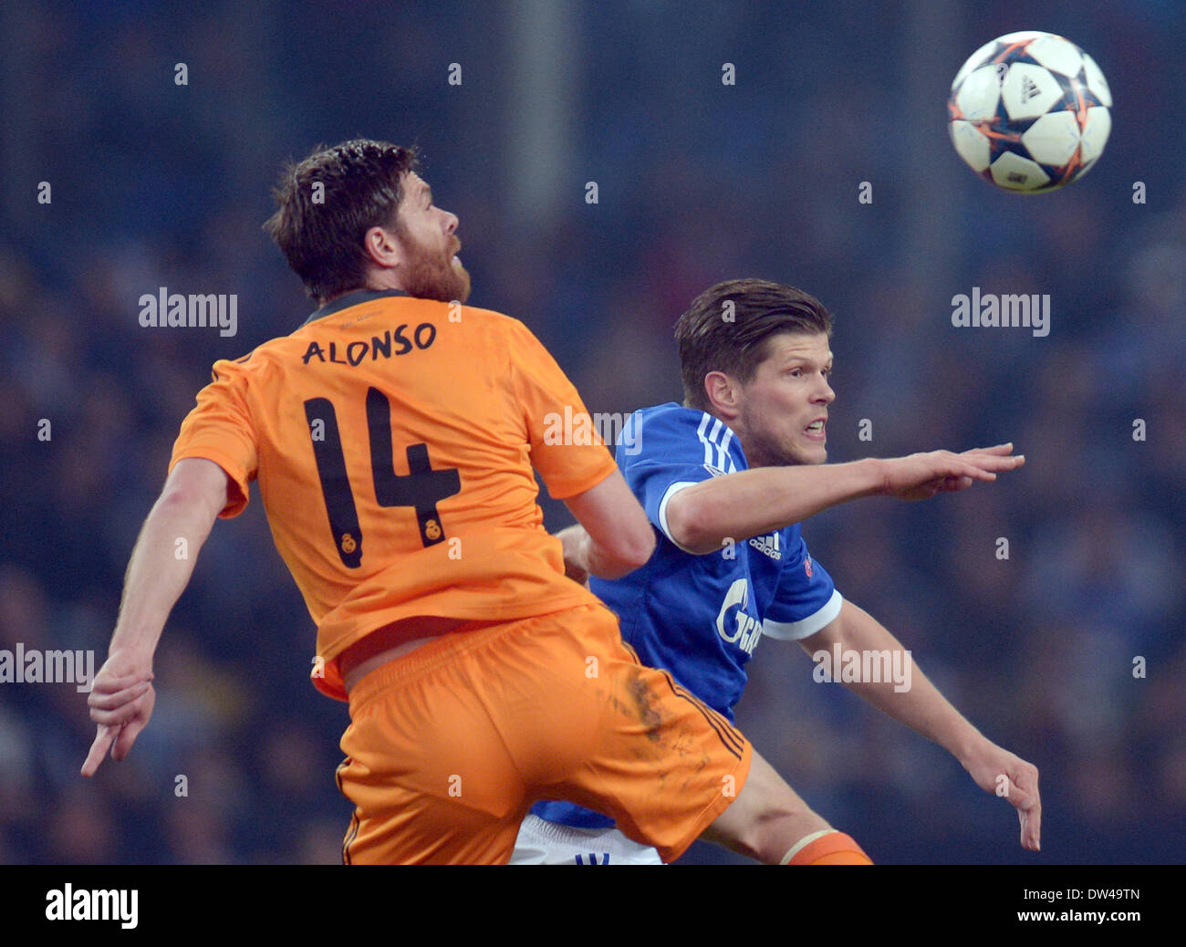 Gelsenkirchen, Germany. 26th Feb, 2014. Madrid's Xabi Alonso (L) vies for the ball with Schalke's Klaas-Jan Huntelaar (R) during the Champions League round of sixteen match between FC Schalke 04 and Real Madrid at Stadium Gelsenkirchen in Gelsenkirchen, Germany, 26 February 2014. Photo: FEDERICO GAMBARINI/dpa/Alamy Live News Stock Photo