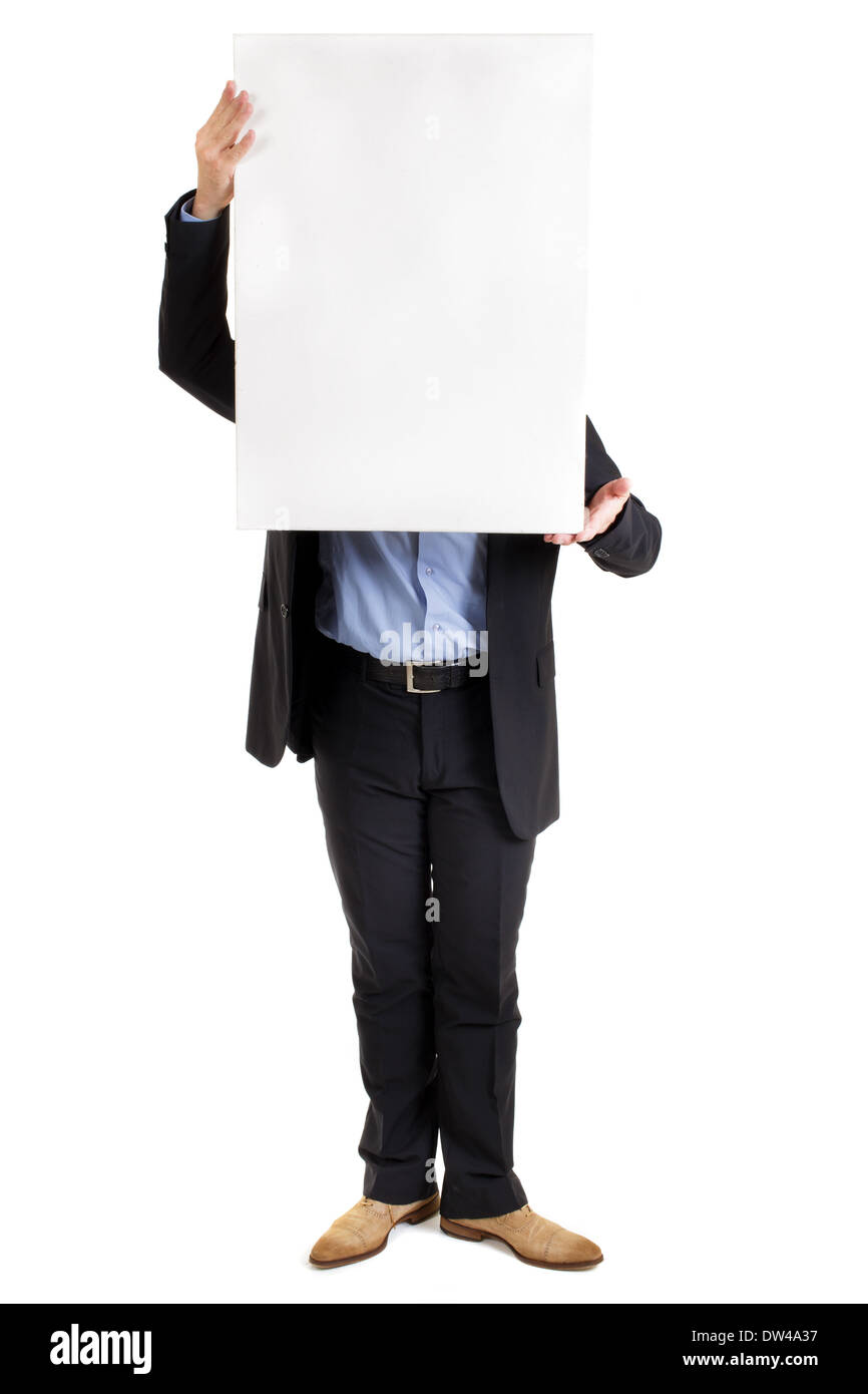 businessman holding up a blank white rectangular sign or placard with copyspace for your text in front of his face concealing it Stock Photo
