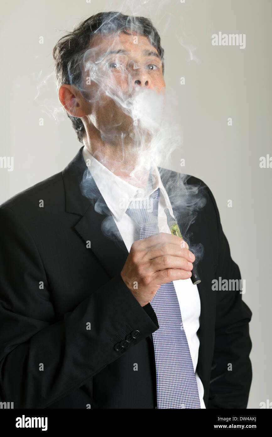 Businessman smoking electronic cigarette Stock Photo