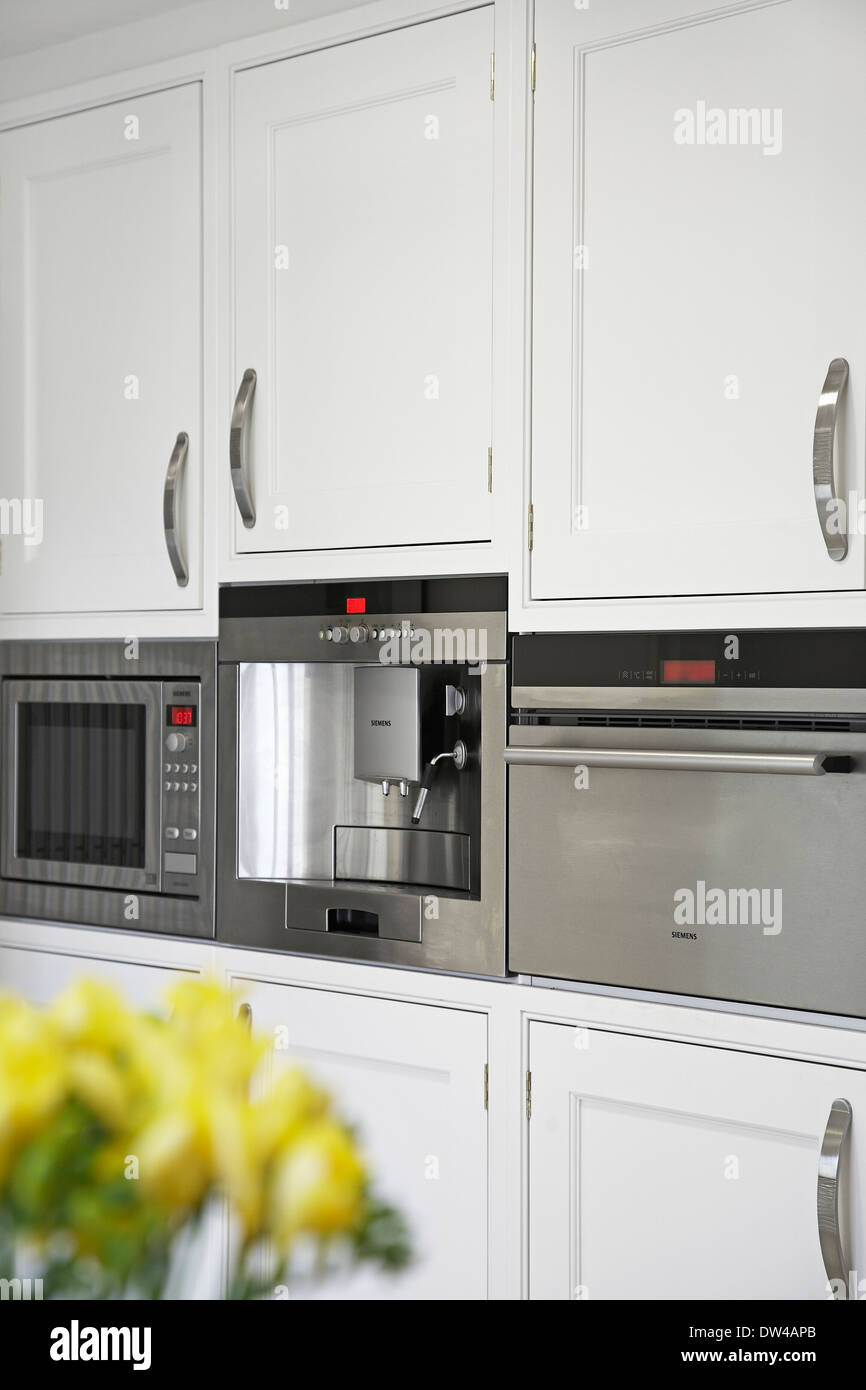Detail of a modern white kitchen in the UK, showing a microwave and