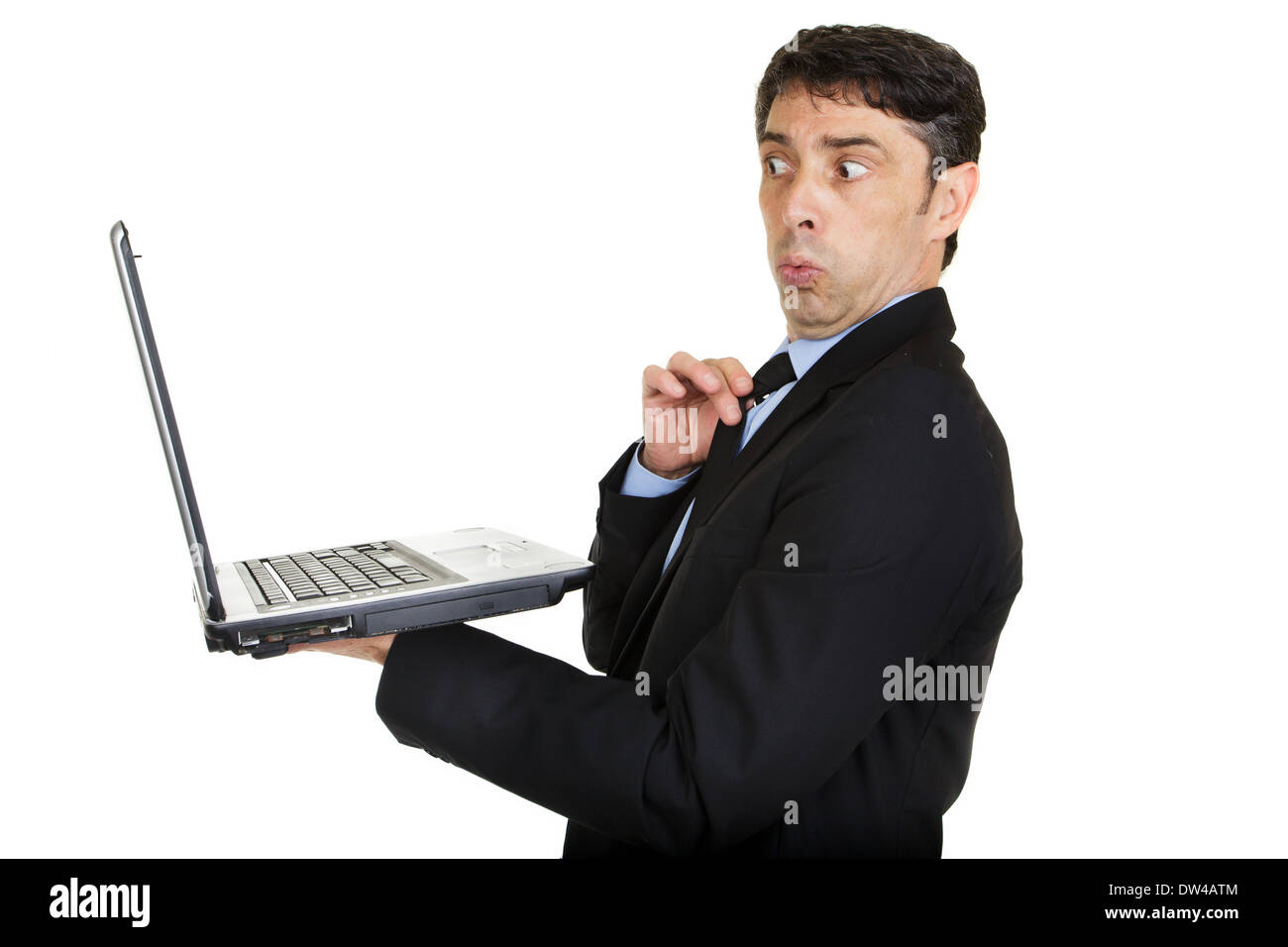 Man looking taken aback and affronted as he looks at the screen of his handheld laptop computer Stock Photo