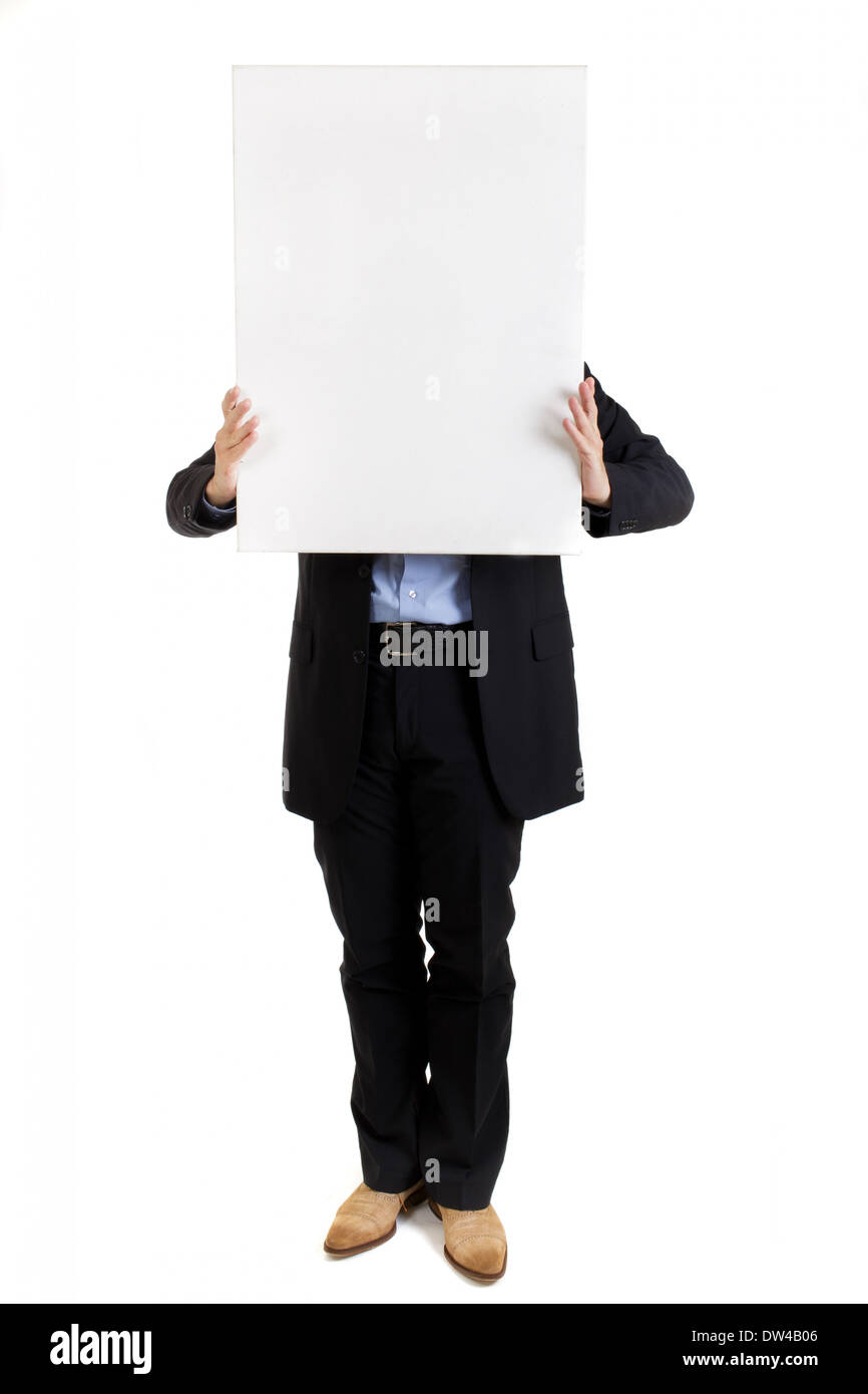 Businessman holding up a blank white rectangular sign or placard with copyspace for your text in front of his face concealing it Stock Photo