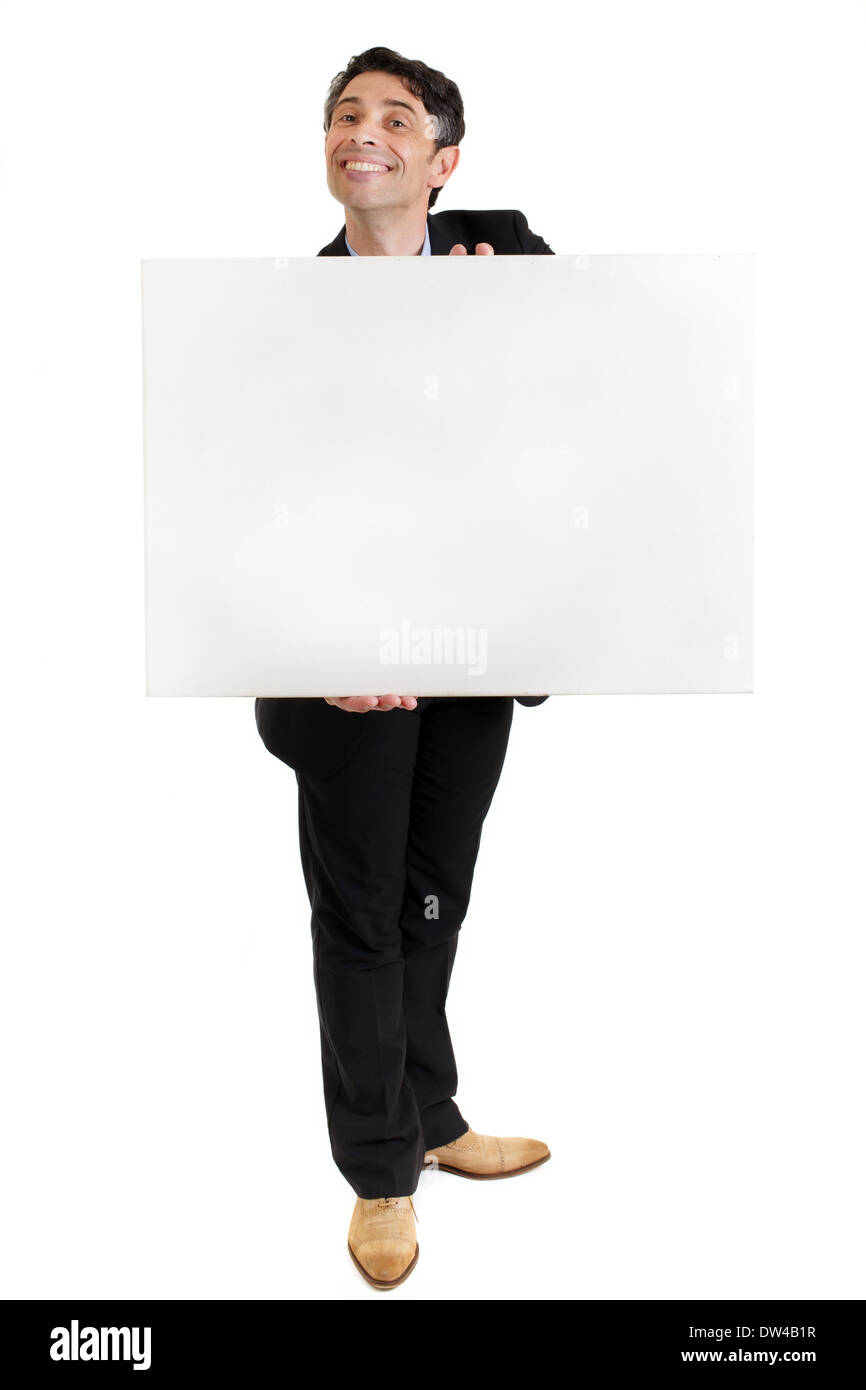 Smart, middle-aged businessman with a cheesy insincere toothy grin holding a blank white sign in his hands with copyspace Stock Photo
