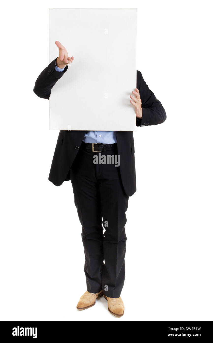 Businessman in a smart suit standing with a blank white sign held in front of his face gesturing with his hand Stock Photo