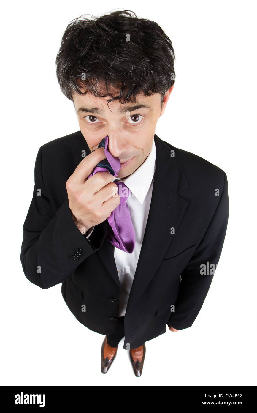 Businessman tapping the side of his nose with his finger and tie to signify that what he is being asked is a secret. Stock Photo