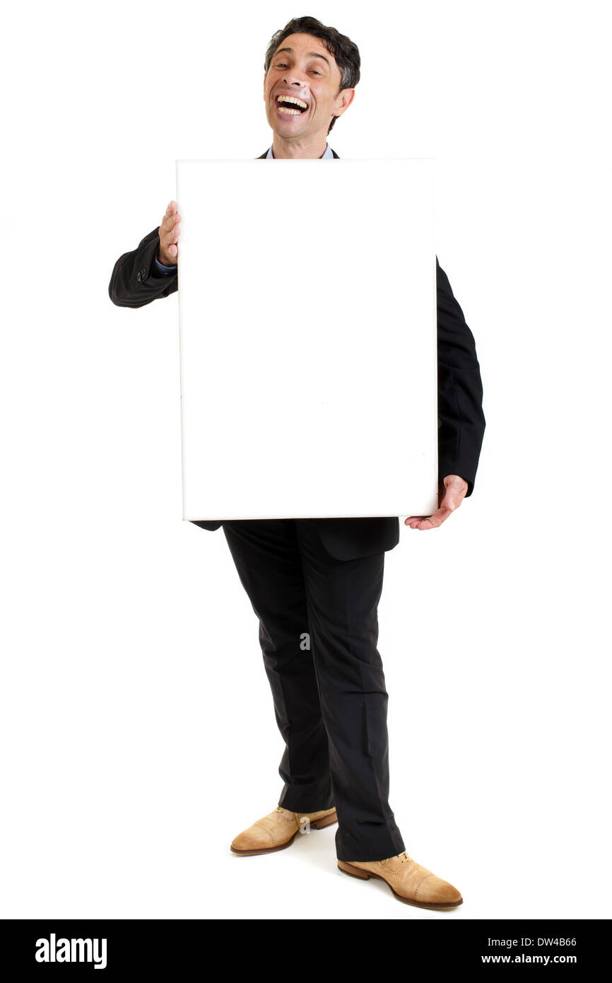 hearty salesman with a cheesy wide toothy smile standing holding a blank rectangular sign board in front of his chest. Stock Photo