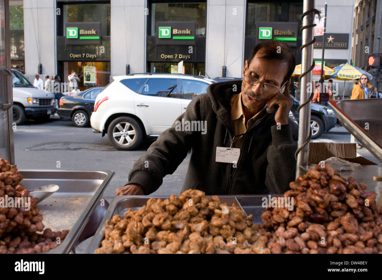 Street vendor selling roasted nuts to tourists on street corner new