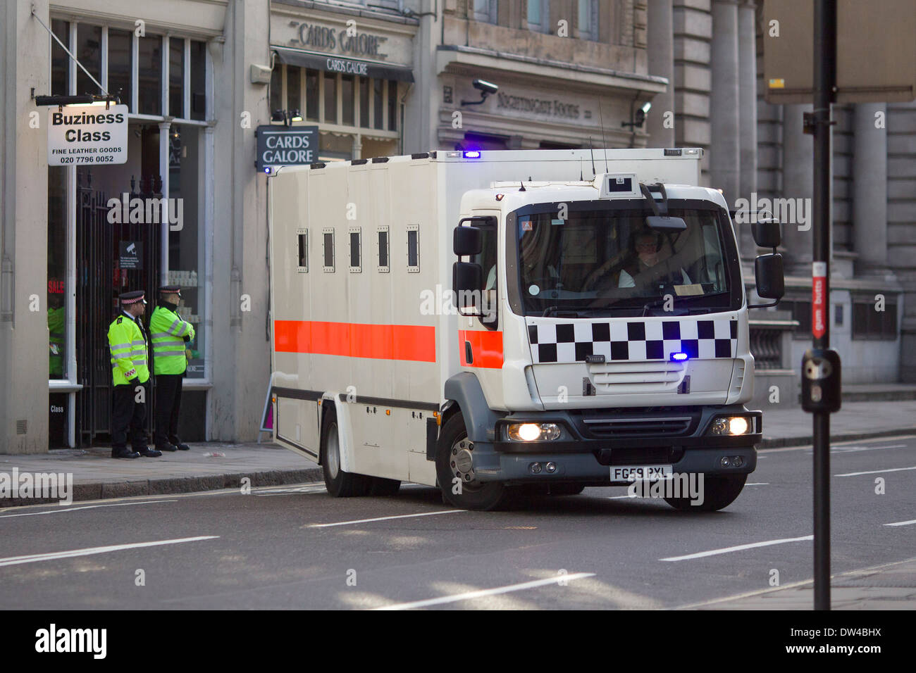 Armed City of London Police convoy escorts a prison van as it arrives at the Old Bailey in London. Stock Photo