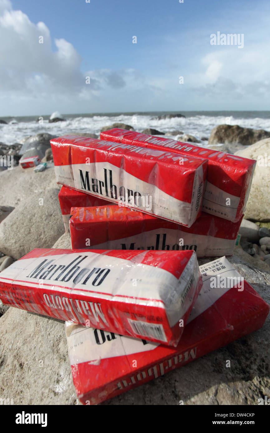 Cigarettes washed up on beach after container spill, Chesil beach Dorset, Portland UK Stock Photo