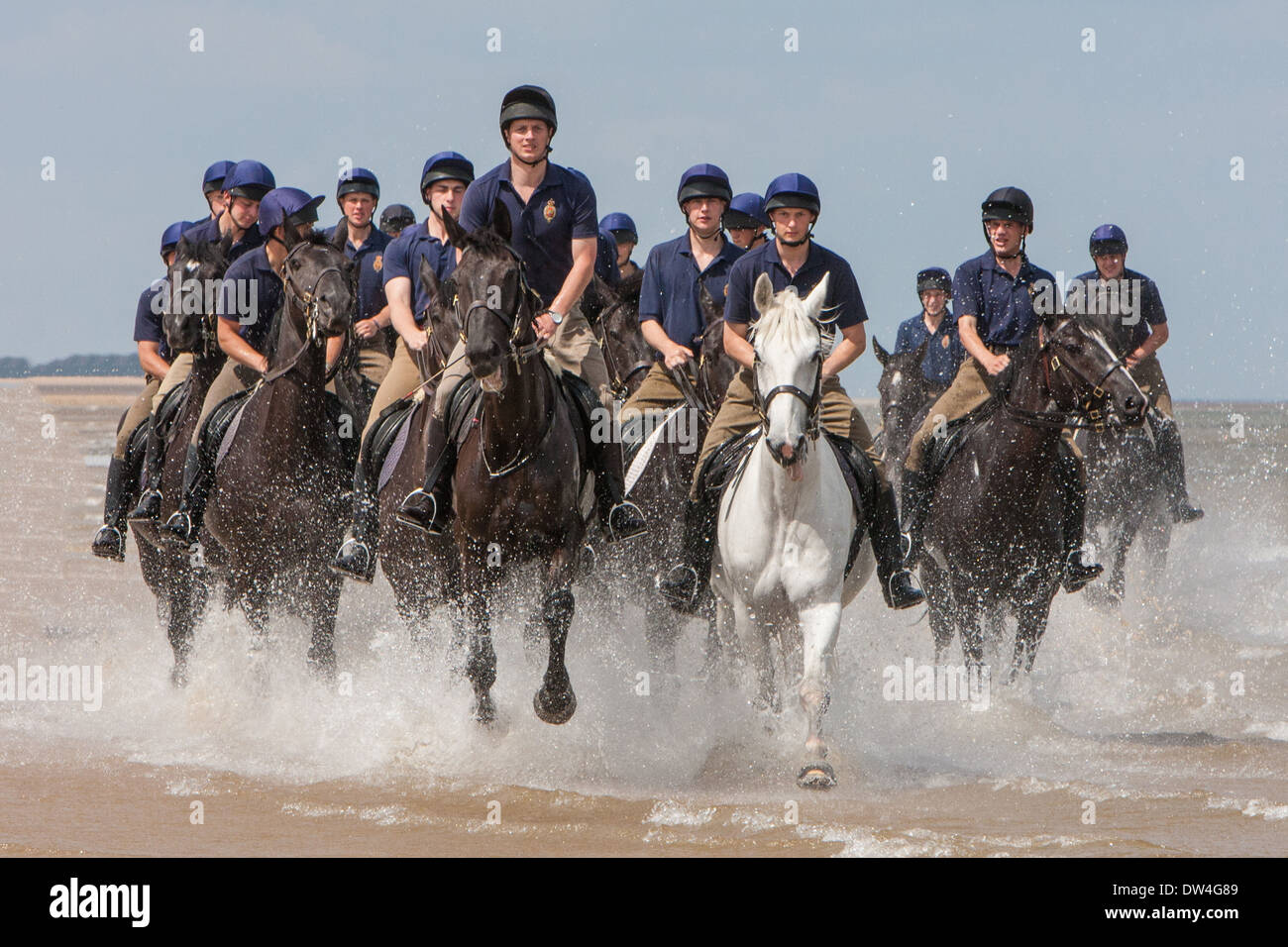Horsemen and women of the Blues and Royals exercising their horses in the surf at Holkham Beach Norfolk, United Kingdom Stock Photo