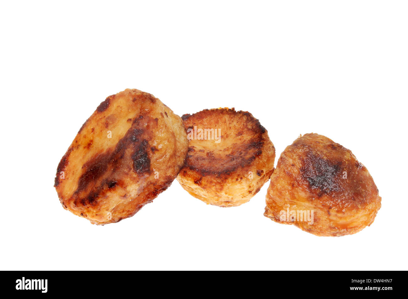 Three roast potatoes isolated against white Stock Photo