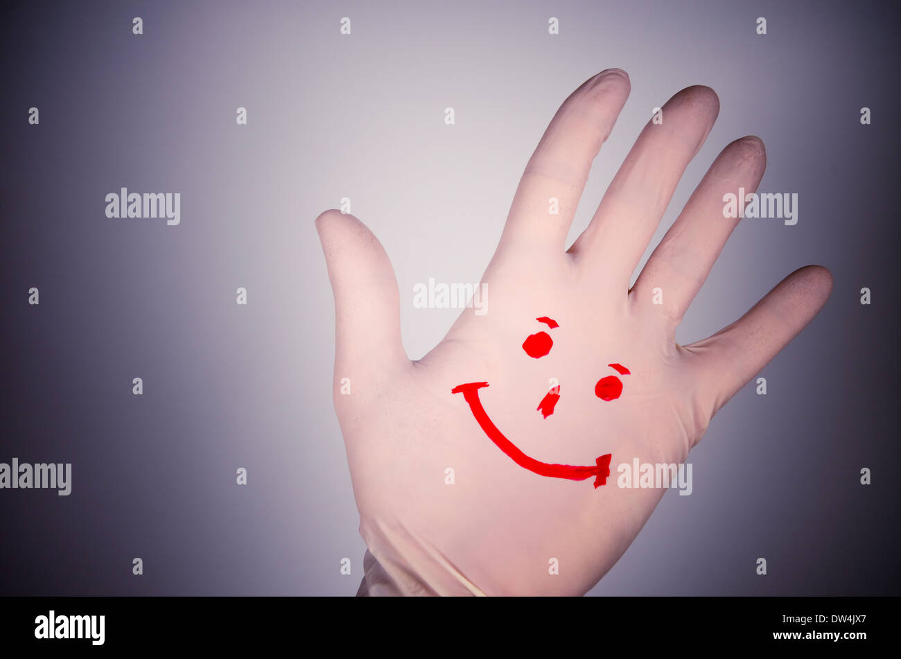 Positive reaction against disease. Smiling drawing on hand plastic glove. Stock Photo
