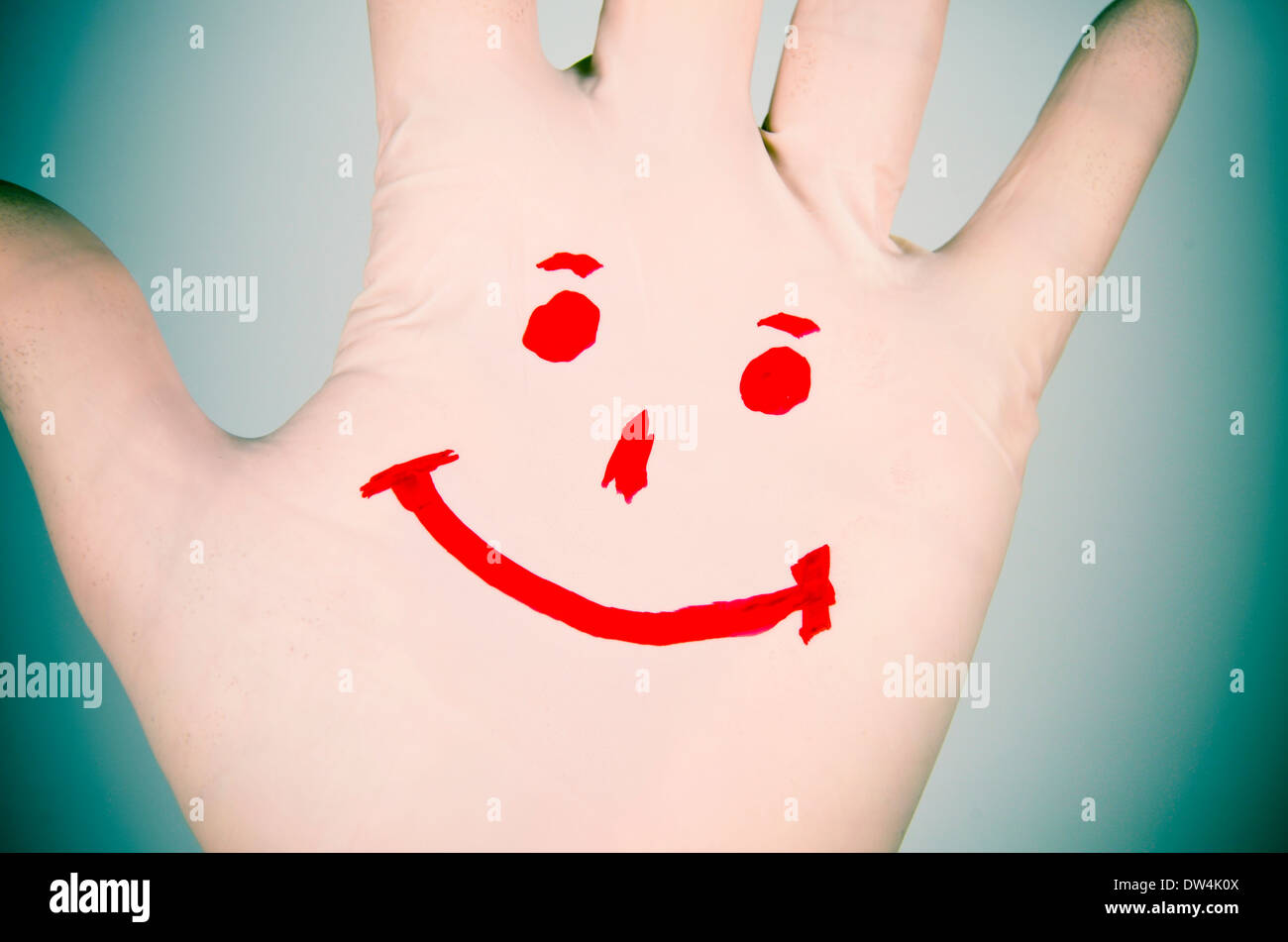 Smile drawn on a hand plastic glove. Positive reaction against disease. Stock Photo