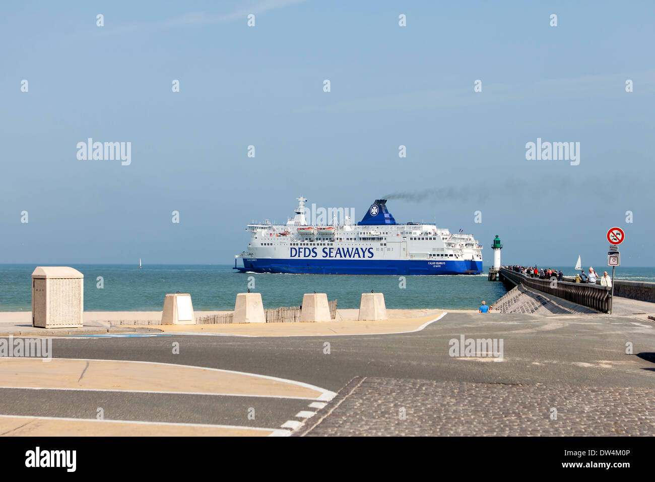 Ferry departing the harbour of Calais, France. It is a sunny morning and a lot of people on the pier. Stock Photo