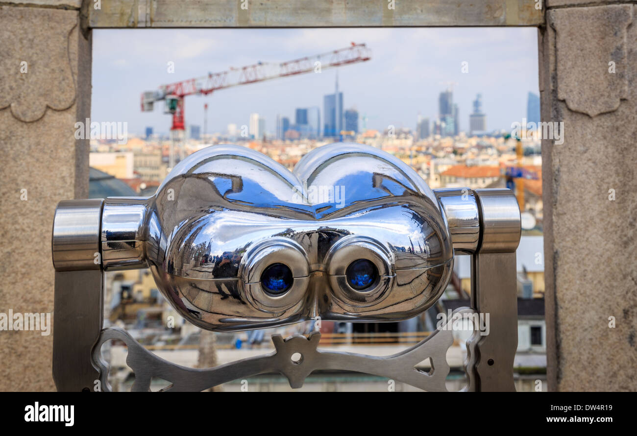 Coin operated binoculars pointing towards Milan skyline, Milan Cathedral, Italy Stock Photo