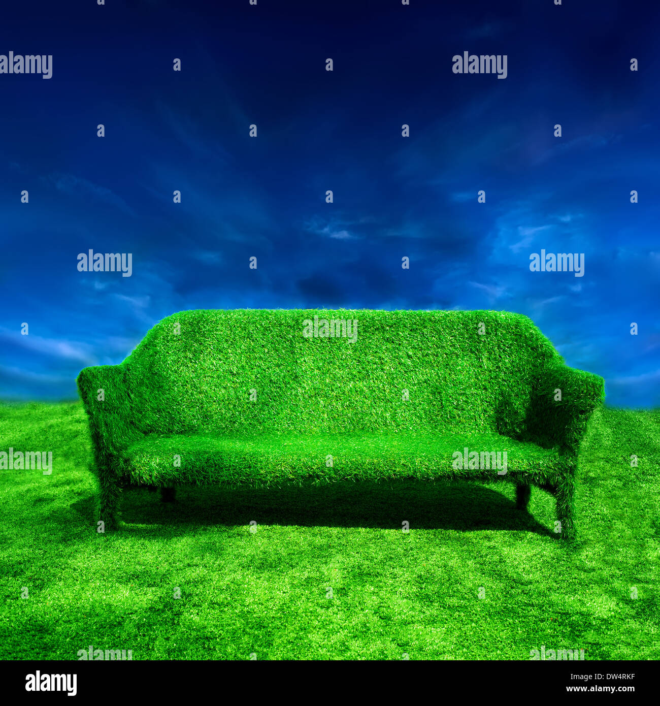 Ecology concept background. Grassy sofa standing at green grass over blue sky Stock Photo