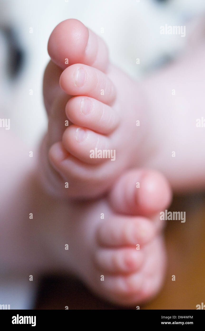 The feet of a newborn caucasian baby crossed showing the child's toes & nails Stock Photo