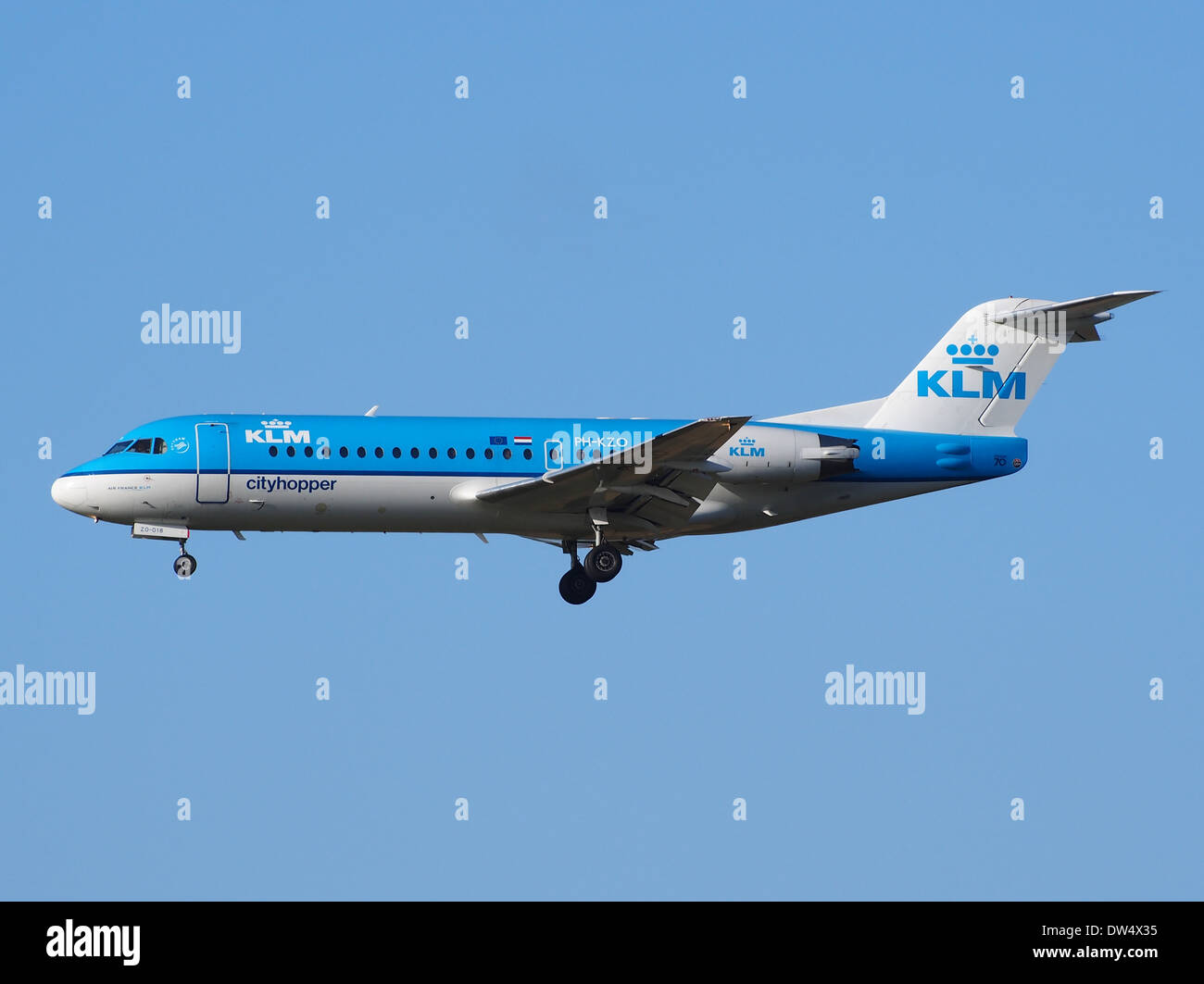 The KLM Cityhopper aircraft, a Fokker 70/100, is seen landing at Schiphol Airport. This regional jet, known for its efficiency and short-range capabilities, is an important part of KLM’s fleet for European routes. Stock Photo
