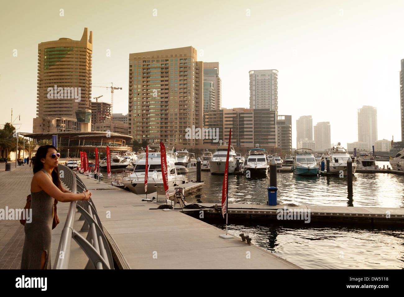 A woman looking out over Dubai Marina at sunset, Dubai, United Arab Emirates, UAE, Middle East Stock Photo