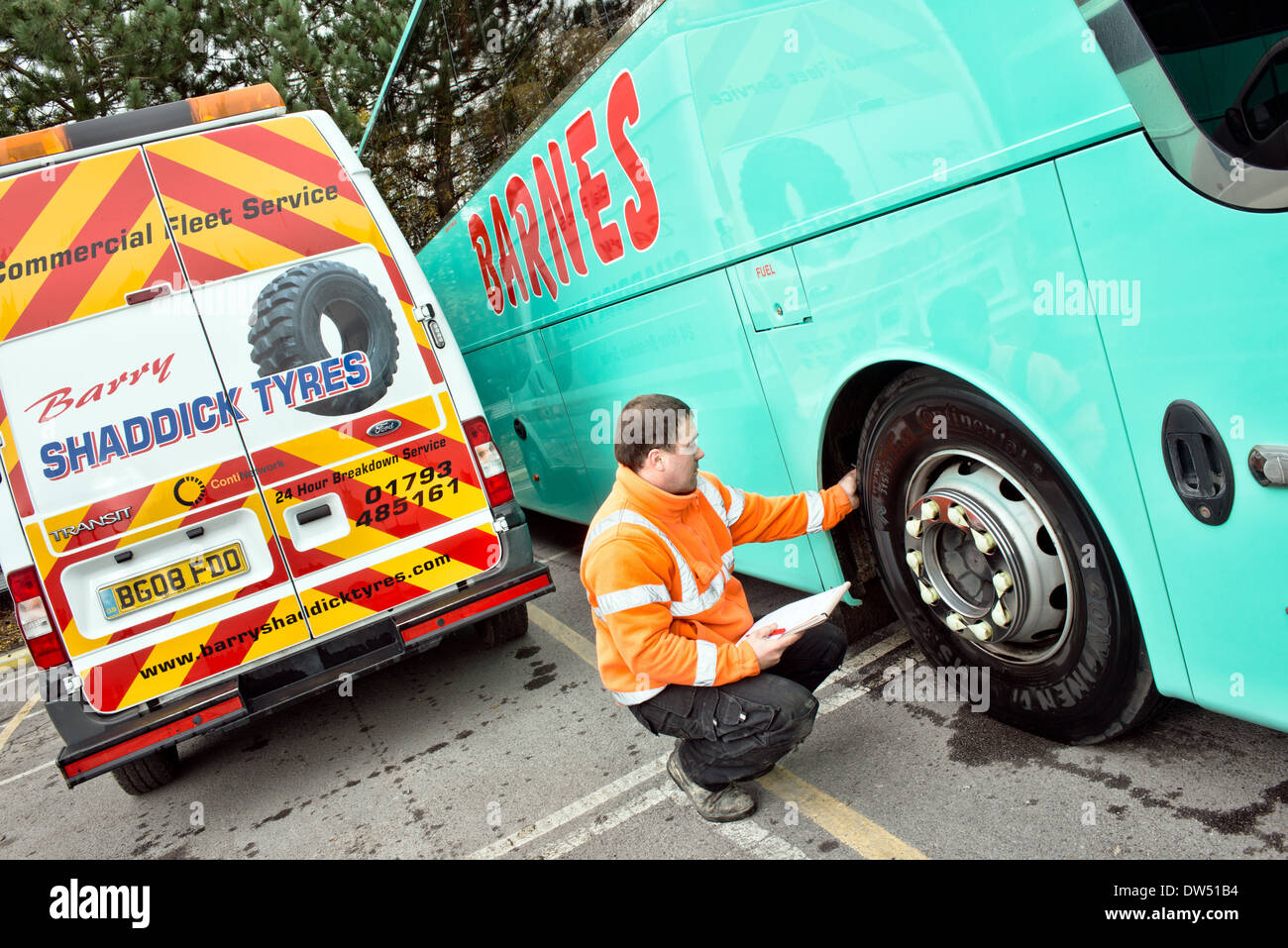 A mobile mechanic / tyre fitter checks a coaches continental tire for tread depth during a regular service & safety inspection Stock Photo