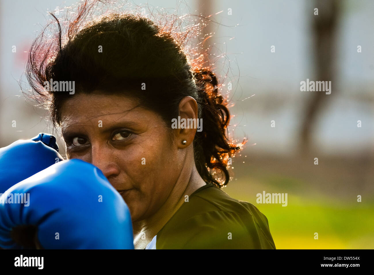 A Peruvian woman practices defense while training in the outdoor boxing school in Callao, Peru. Stock Photo
