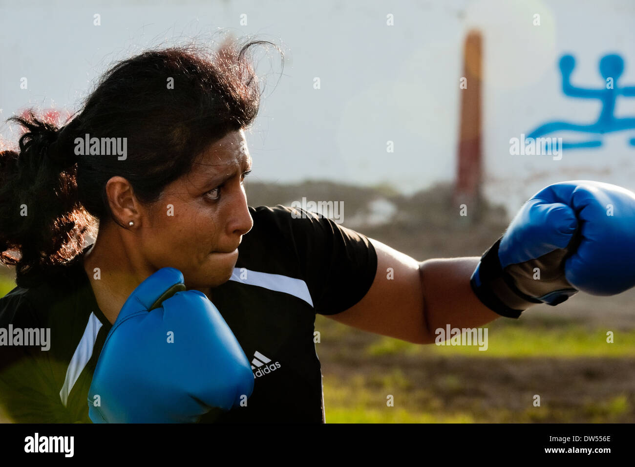 A Peruvian woman practices punching while training in the outdoor boxing school in Callao, Peru. Stock Photo